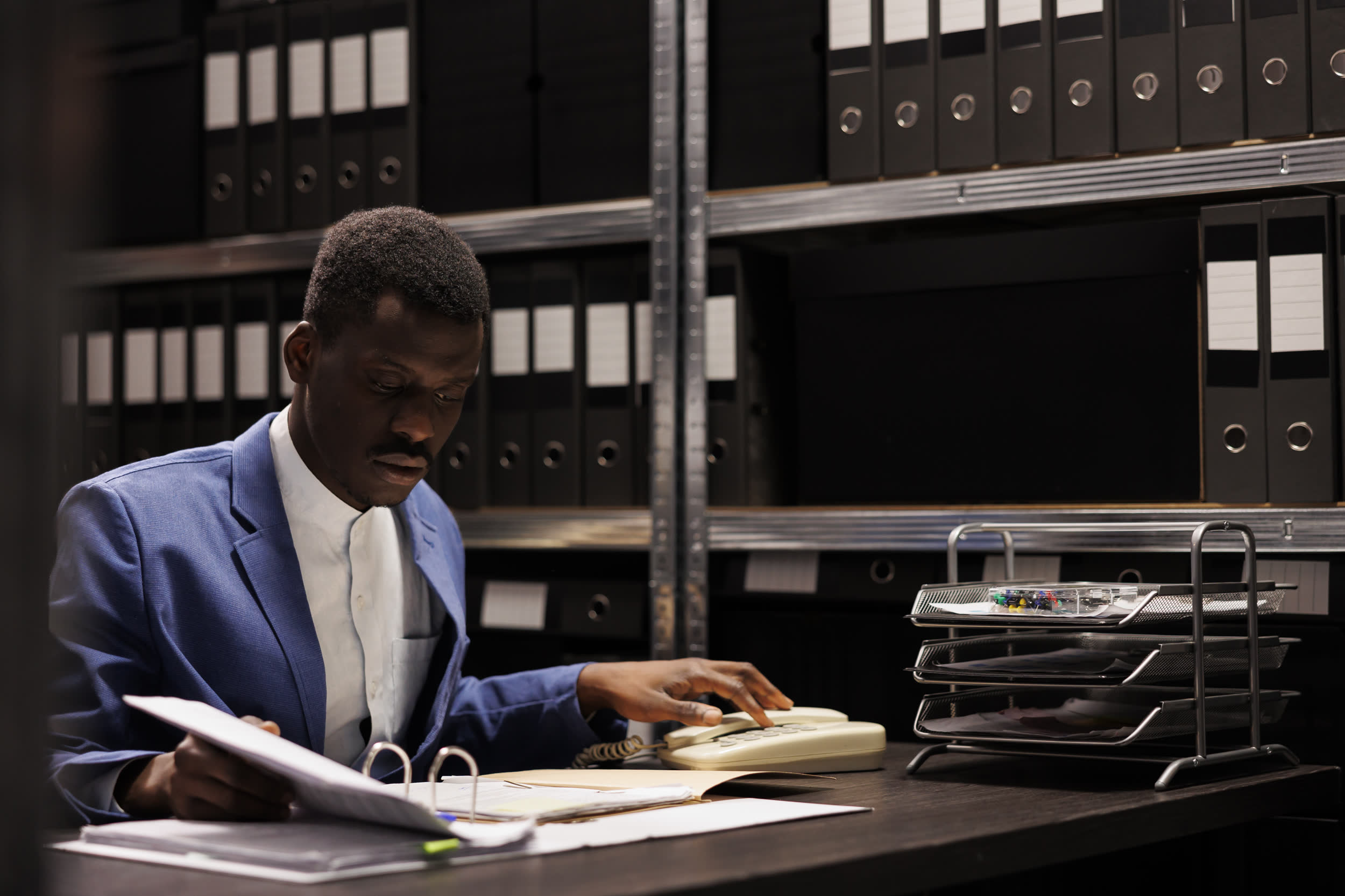 Lawyer reviewing documents in a dimly lit records room